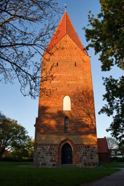 Rerik, Almanya - 29 Mayıs 2021: Almanya 'nın Rerik kentinde bir bahar gecesi bir kilisenin önünde güneş parlıyor.