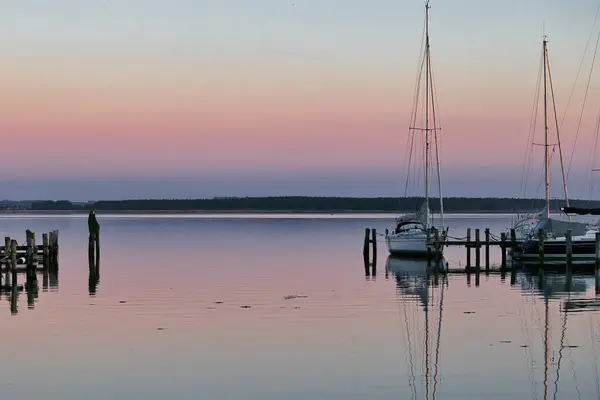 stock image Rerik, Germany - May 29, 2021: Colorful pink and purple sky and reflection in the water at the Baltic Sea at sunset.