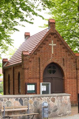 Rerik, Almanya - 30 Mayıs 2021: Bir bahar günü Almanya 'nın Rerik kentinde küçük bir kilise üzerinde yeşil yapraklı ağaçlar.