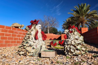 Silves, Portekiz - 27 Aralık 2019: Silves, Portekiz 'de güneşli bir kış gününde Silves Şatosu' ndaki bir kaya bahçesinde tavuk heykelleri.