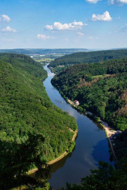 Almanya 'da güneşli bir bahar gününde yeşil ağaçlarla çevrili Saar nehri..