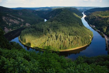 Sun shining on green trees in the Saar River horsebend on a spring aternoon in Germany. clipart