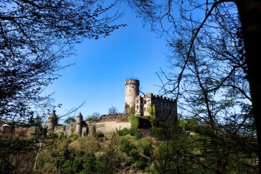 Bad Pyrmont, Almanya - 21 Nisan 2019: Almanya 'da güneşli bir bahar gününde ağaçlı bir tepedeki Pyrmont Şatosu.