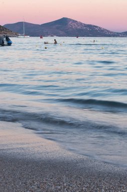 Atina, Yunanistan 'da bir sonbahar akşamı gün batımında bir dağın arkasındaki renkli gökyüzü.