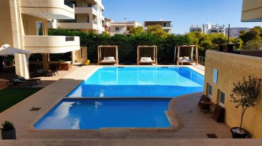 Atina, Yunanistan - 25 Eylül 2021: Atina, Yunanistan 'da sıcak bir sonbahar gününde bir otelin havuzunda güneş parlıyor.