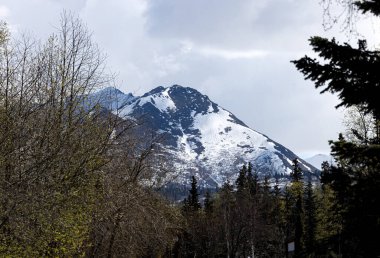 Anchorage, Alaska 'da bir dağda hafif kar bulutlu bir bahar gününde.