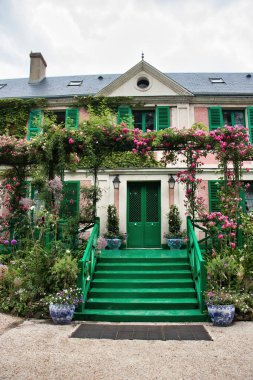 Giverny, Fransa - 23 Haziran 2021: Monet 'nin Giverny, Fransa' daki evinin önünde merdivenler ve pembe çiçekler.