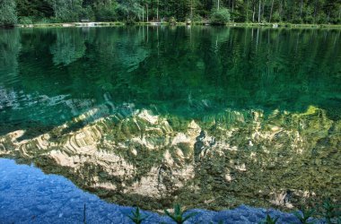 Avusturya 'da bir bahar akşamı Bluntautal Vadisi' ndeki bir gölde dağların ve ağaçların yansıması..