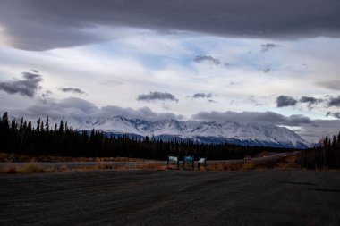 Kanada 'da bir sonbahar günü Alaska otoyolunun arkasında karla kaplı dağlar. 