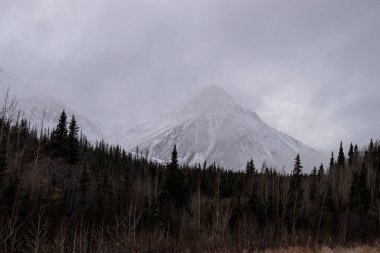 Kanada 'daki Alaska Otoyolu' nda sonbahar günü dağların üzerinde gri bulutlar. 