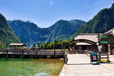 Schonau am Konigssee, Almanya - 15 Haziran 2021: Almanya 'da güneşli bir ilkbahar gününde arka planda dağlarla birlikte Konigssee limanı.