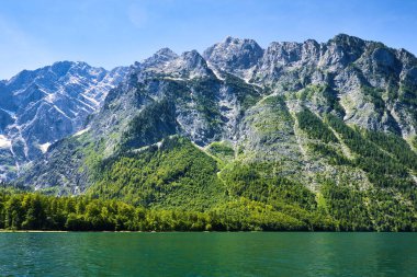 Almanya 'nın Bavyera kentindeki Konigssee' de açık, güneşli bir ilkbahar gününde suyun üzerindeki dağlar.