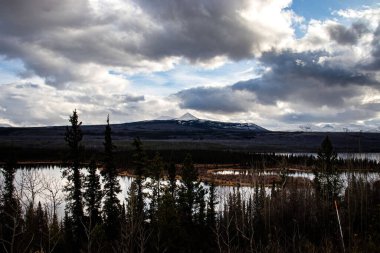 Kanada 'da soğuk, karanlık bir sonbahar öğleden sonrasında uzak dağları olan küçük bir göl.. 