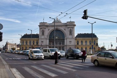 Budapeşte, Macaristan - 26 Ekim 2021: Macaristan 'da güneşli bir sonbahar gününde Budapeşte Keleti İstasyonu önündeki bir yolda arabalar ve yayalar.