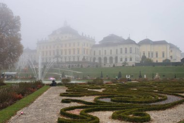 Ludwigsburg, Almanya - 11 Kasım 2021: Almanya 'da sisli bir sonbahar gününde balkabağı festivali sırasında Ludwigsburg Sarayı' nın arkasındaki bahçe ve çeşme.