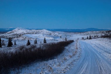 Karlı yol kışın öğleden sonra tepeye çıkar Delta Kavşağı, Alaska yakınlarında.. 