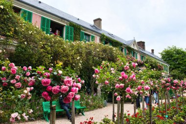 Giverny, Fransa - 23 Haziran 2021: Fransa 'nın Giverny şehrinde bir yaz günü Monet' nin evinin önündeki bahçede pembe güller.