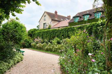 Giverny, Fransa - 23 Haziran 2021: Fransa 'nın Giverny şehrinde bir yaz günü Monet' nin evinin önündeki patikada yürümek.