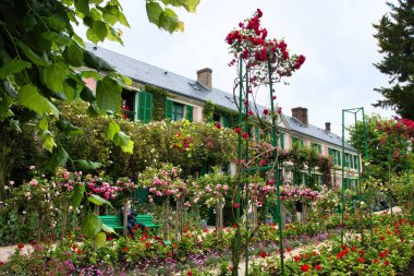 Giverny, Fransa - 23 Haziran 2021: Fransa 'nın Giverny şehrinde bir yaz günü Monet' nin evinin önünde çiçekler.