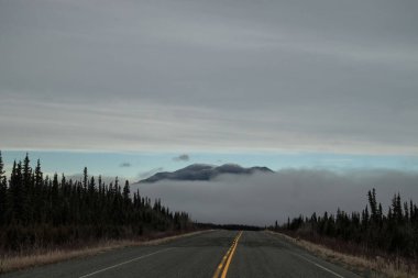 Kanada 'daki Alaska Karayolu bir sonbahar günü sisle kaplı dağa çıkar.. 