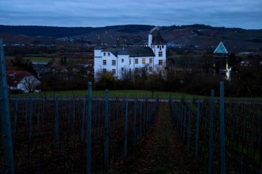 Nennig, Almanya - 19 Kasım 2021: Almanya 'da bulutlu bir sonbahar akşamında Victor' s Residenz Hotel Schloss Berg 'de bacadan çıkan duman.