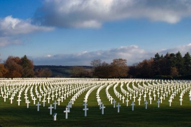 Henri-Chapelle, Belçika - 22 Kasım 2021: Belçika 'nın aydınlık bir sonbahar gününde Henri-Chapelle Amerikan Mezarlığı ve Anıtı' ndaki haçlar üzerinde güneş parlıyor.