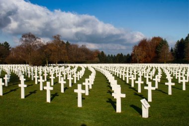 Henri-Chapelle, Belçika - 22 Kasım 2021: Belçika 'nın aydınlık bir sonbahar gününde Henri-Chapelle Amerikan Mezarlığı' nda haçlar ve gölgeler.