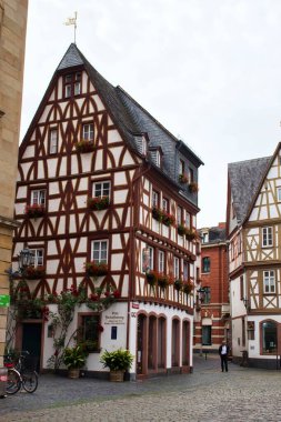 Mainz, Almanya - 25 Haziran 2021: Mainz, Almanya 'da bir yaz gününde kaldırım taşı yolunda çiçek kutularıyla dolu yarım kereste bina. 