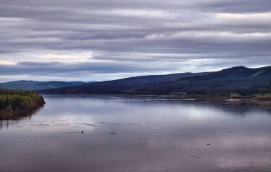 Alaska 'da bulutlu bir bahar gecesinde Dalton otoyolu boyunca Yukon Nehri. 