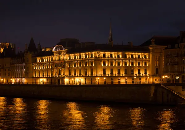 Paris, Fransa - 4 Aralık 2021: Paris, Fransa 'da bir kış gecesi Seine Nehri' nin yanındaki Conciergerie Müzesi.