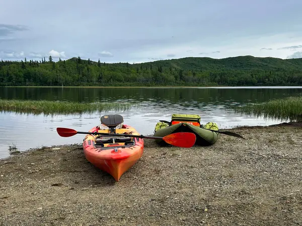 Delta Junction, Alaska - 10 Haziran 2021: Alaska 'nın iç kesimlerinde bir bahar günü İkiz Göllerden birinin yanında oturan kanolar. 