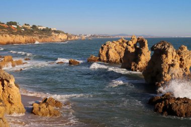 Güney Portekiz 'de güneşli bir kış gününde Atlantik Okyanusu' ndaki kayalar ve kayalıklar. 