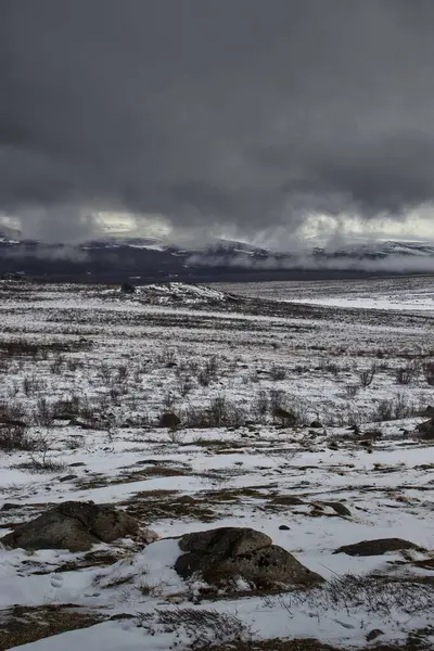 Alaska 'da karlı bir bahar gününde Dalton Karayolu boyunca dağların üzerinden sis ve kara bulutlar.. 