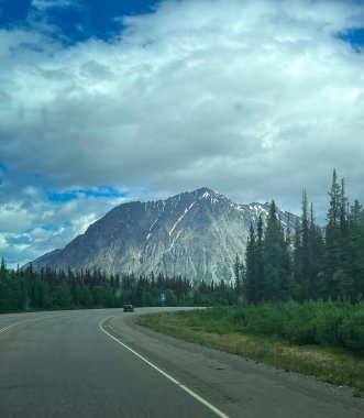 Bir bahar günü Anchorage, Alaska yakınlarındaki yolun arkasındaki yolda ışık parlıyor.. 