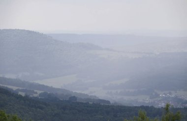 Almanya 'nın Bavyera kentindeki Kreuzberg Manastırı' nda bir yaz günü tepelerin üzerinde sis tabakası.