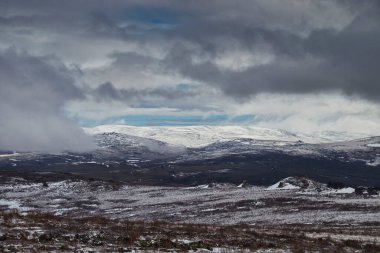Alaska 'daki Dalton Otoyolu' nda bir bahar günü, etrafım kara bulutlarla çevrili, karlı dağlarda parlayan güneş.. 