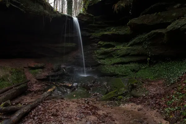 Almanya 'nın Palatinate Ormanı' nda karanlık bir kış gününde Hexenklamm 'da kayalarla çevrili bir şelale.