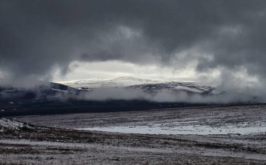 Alaska 'daki Dalton Otoyolu' nda, karlı, karanlık bir bahar gününde, sisli bir dağ açıklığında.. 