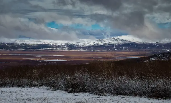 Alaaka 'da bir bahar günü Dalton otoyolunun yanındaki karlı moiuntain etrafındaki bulutlar. 