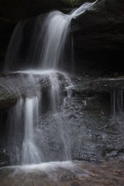 Almanya 'nın Palatinate Ormanı' nda bir kış günü Hexenklamm 'da kayaların üzerinden akan su.
