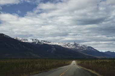Alaska 'da bulutlu bir bahar gününde Dalton Karayolu etrafındaki dağlar. 