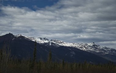 Alaska 'da bir bahar günü, Dalton Otobanı' nda, dağların tepesinde güneş parlıyor.. 