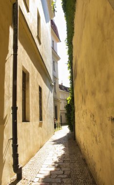 Prag, Çek Cumhuriyeti - 3 Temmuz 2021: Prag 'da bir yaz günü binaların arasında küçük bir ara sokak.