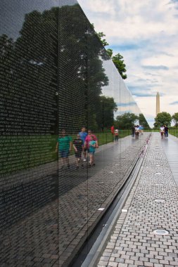 Washington DC, ABD - 9 Haziran 2024: Washington D.C. 'de bir bahar günü Vietnam Anıtı' nda yürüyen insanların yansımaları.