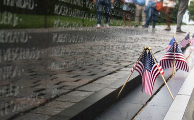 Washington DC, ABD - 9 Haziran 2024: Bayraklar ve Washington DC 'de bahar günü Vietnam Gazileri Anıtı' ndaki yansımaları.