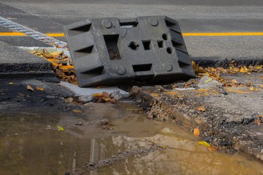 Değirmende asfalt yol yaması ve şantiyede su birikintisi.