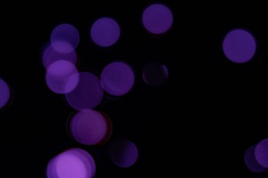 Siyah arkaplanda mor bulanık bokeh ışıkları