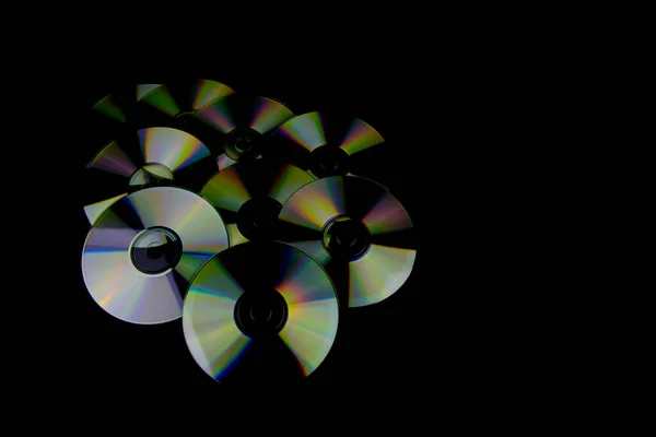 カラフルな光の反射と黒の背景に隔離されたCdとDvd — ストック写真