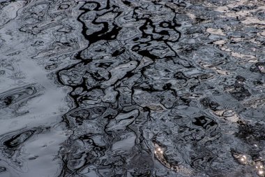 Suyun yansıtıcı yüzeyinde soyut desenler ve dalgalanmalar oluşur, tek renkli tonlarda güzel bir ışık ve gölge oyunu sergilerler, dinginlik ve minimalizm hissi uyandırır..