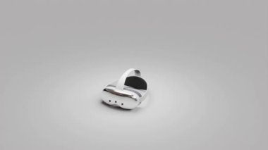 Gri arka planda beyaz bir VR kulaklığın 360 derecelik görüntüsü. Gösterişli tasarım, kıvrımlı kenarlar ve ayarlanabilir kayışlar açıkça görülebilir, minimalist bir ortamda modern sanal gerçeklik teknolojisi sergiliyor.